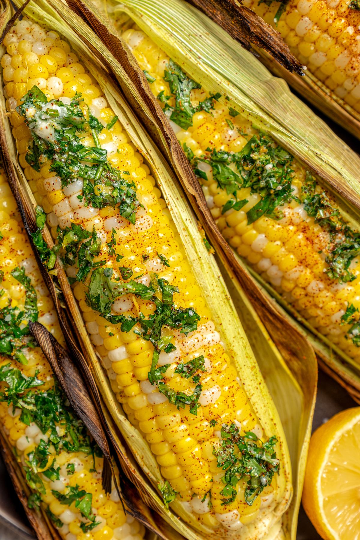 Sweet, fresh corn is a must-have in the summer, and this easy Grilled Corn is loaded with a unique nutty taste that you're sure to love! Close-up shot of corn cooked on the grill.
