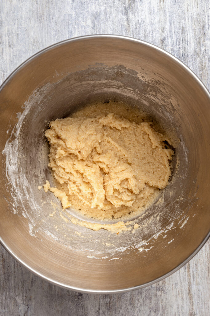 Italian Pignoli Cookies are crispy, chewy and almond-y, topped with rich, creamy pine nuts. They're sure to become a family favorite! Smooth cookie dough in a mixing bowl.