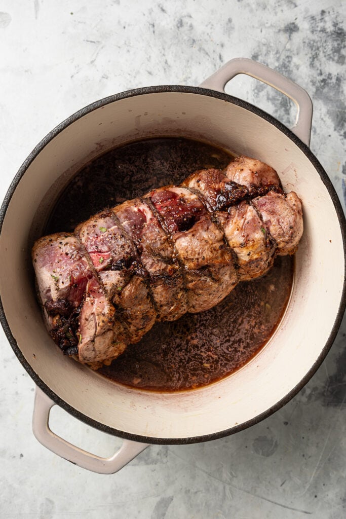 This sweet-and-savory pork shoulder recipe with honey, red wine-fig sauce, and lots of fruity figs is perfect for Thanksgiving dinners. Seared pork in the Dutch oven with red wine for deglazing.