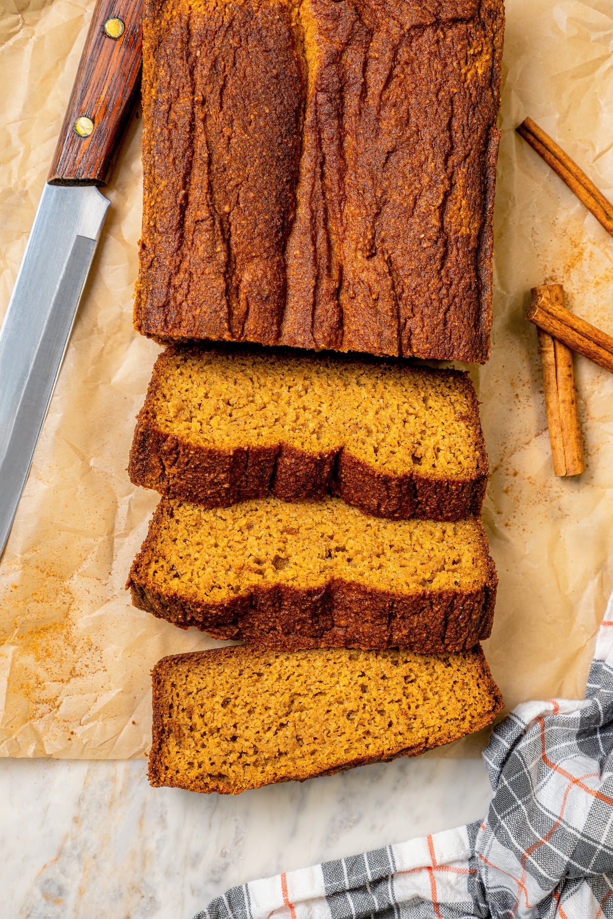 This tender paleo pumpkin bread recipe with vegan flours, coconut cream, and maple syrup is an easy fall-flavored dessert. Sliced paleo pumpkin bread.