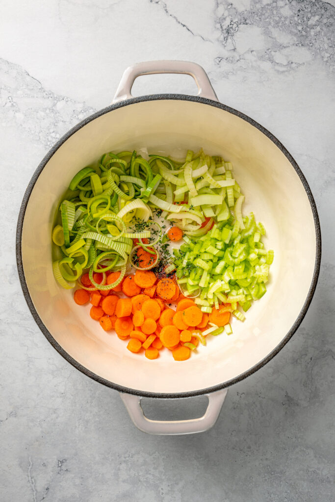 This Easy Salmon Soup is made with fresh salmon, fennel, leeks, and shitake mushrooms. It's unbelievably good, and good for your your body! Sliced fennel, leek, carrots, and celery in a pot.