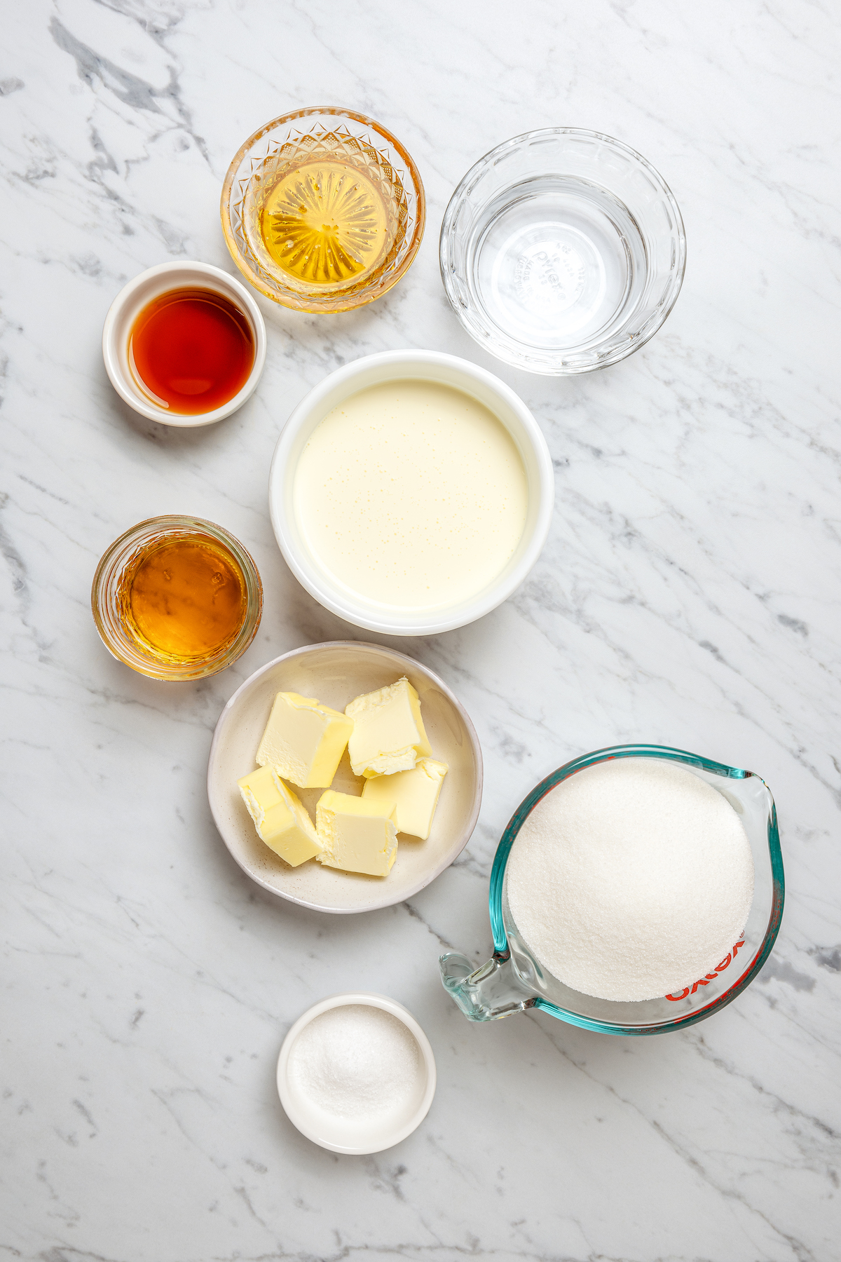 These Whiskey Salted Caramels are the perfect Fall candy recipe - who could resist silky caramel, warm whiskey, and a touch of salt? Ingredients for whiskey salted caramels arranged on a table.