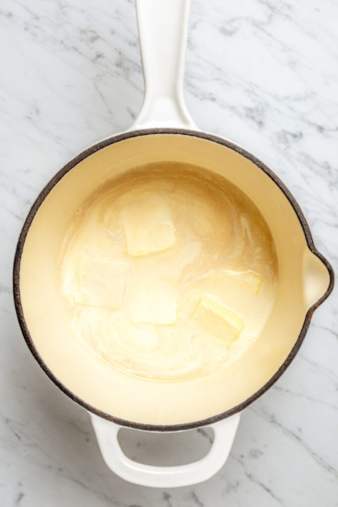 These Whiskey Salted Caramels are the perfect Fall candy recipe - who could resist silky caramel, warm whiskey, and a touch of salt? Making the cream mixture in a saucepan.