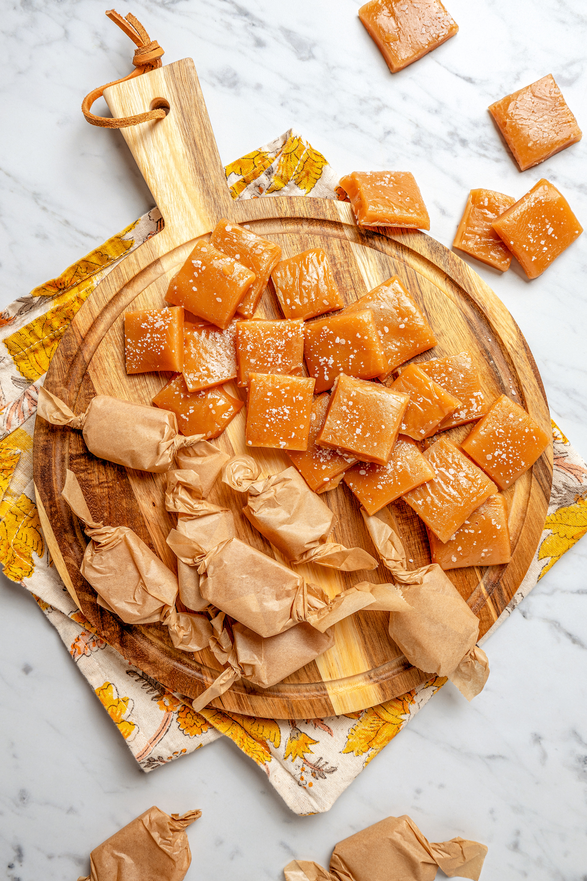 These Whiskey Salted Caramels are the perfect Fall candy recipe - who could resist silky caramel, warm whiskey, and a touch of salt? Whiskey salted caramels wrapped in parchment papers.