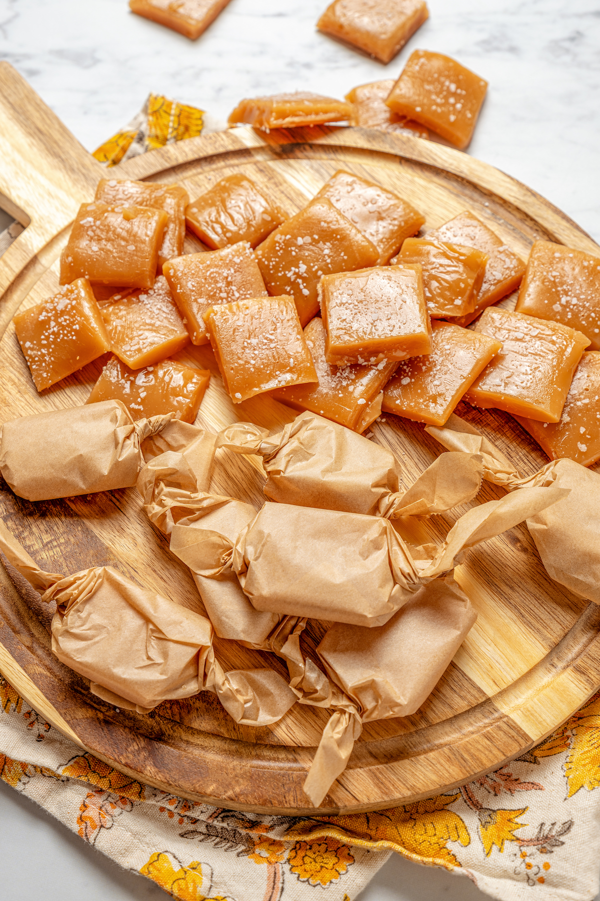 These Whiskey Salted Caramels are the perfect Fall candy recipe - who could resist silky caramel, warm whiskey, and a touch of salt? Homemade caramels on a cutting board.