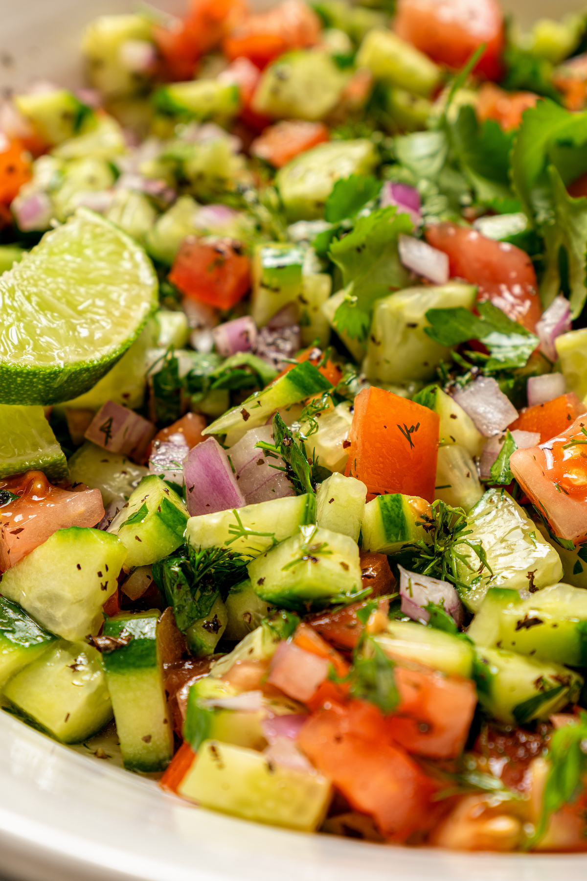 This quick shirazi salad with cucumbers, tomatoes, red onions, and a light vinaigrette is a refreshing Middle Eastern side you'll love. Close-up of shirazi salad in a bowl.