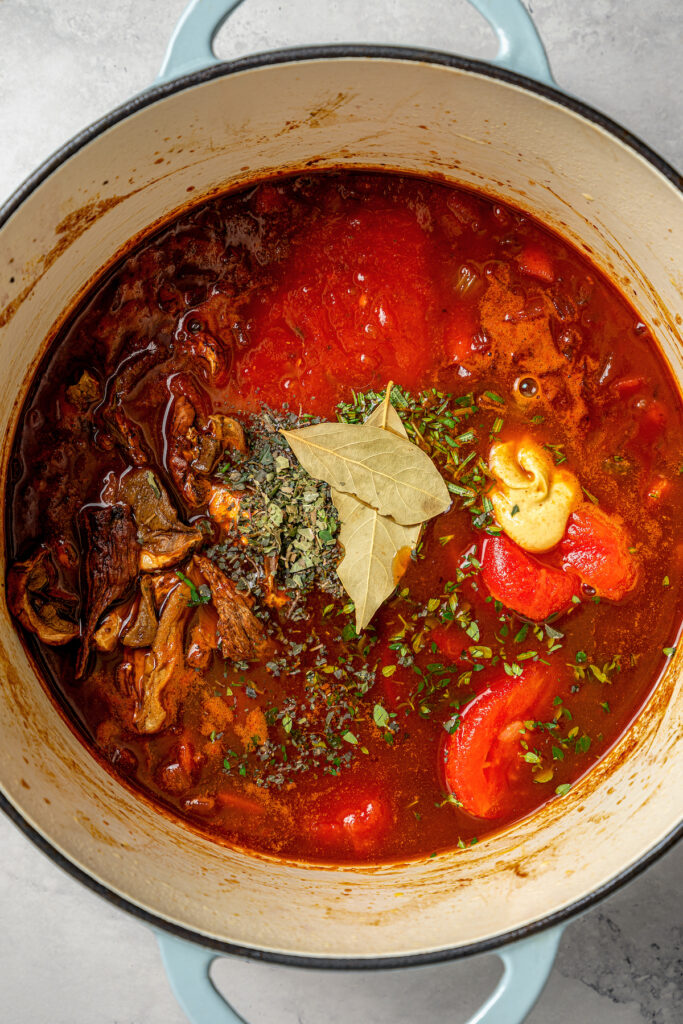 This garlicky slow cooker short ribs recipe with red wine, tender veggies, and dried herbs is an easy but fancy dinner. Adding the herbs to the pot.