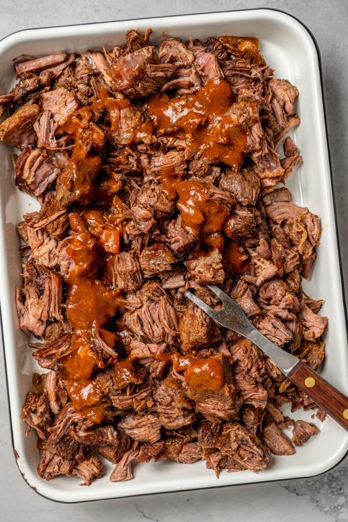 This garlicky slow cooker short ribs recipe with red wine, tender veggies, and dried herbs is an easy but fancy dinner. Shredding the beef.