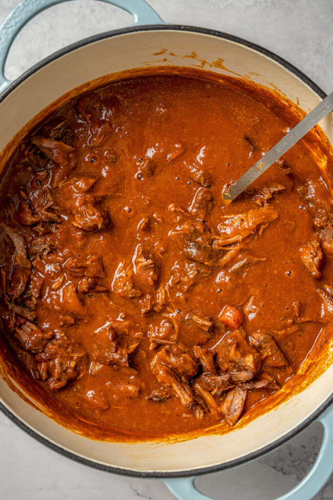 This garlicky slow cooker short ribs recipe with red wine, tender veggies, and dried herbs is an easy but fancy dinner. Short ribs in the Dutch oven with the blended sauce.