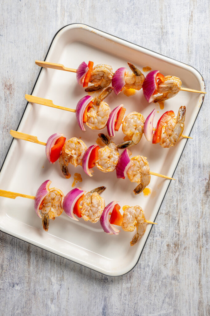 This shrimp brochette recipe with garlic-lemon marinade, sweet bell peppers, and spicy red onions is an easy 20-minute lunch. Raw, assembled skewers.