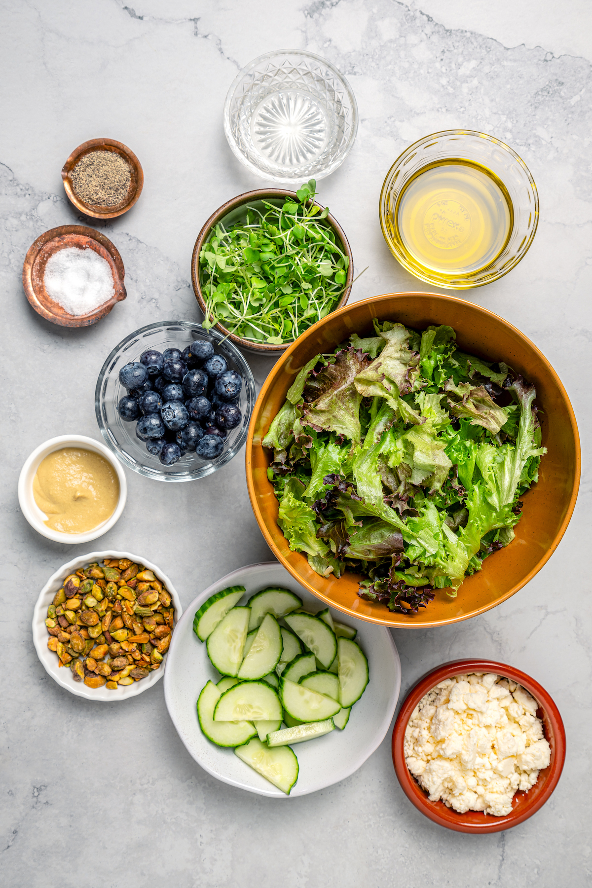 Spring Mix Salad with Champagne Dressing is elegant, flavorful, and unique - and only takes minutes to prepare! A nutritious, paleo salad. Salad ingredients arranged on a table.