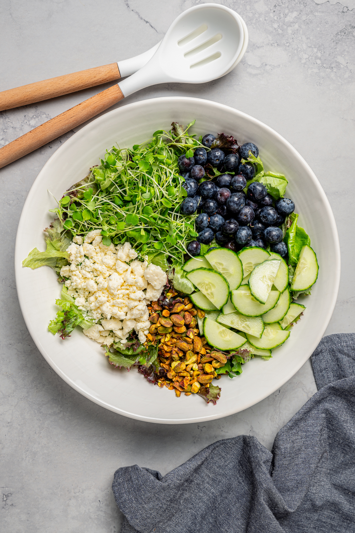 Spring Mix Salad with Champagne Dressing is elegant, flavorful, and unique - and only takes minutes to prepare! A nutritious, paleo salad. Salad ingredients arranged neatly in a large bowl.