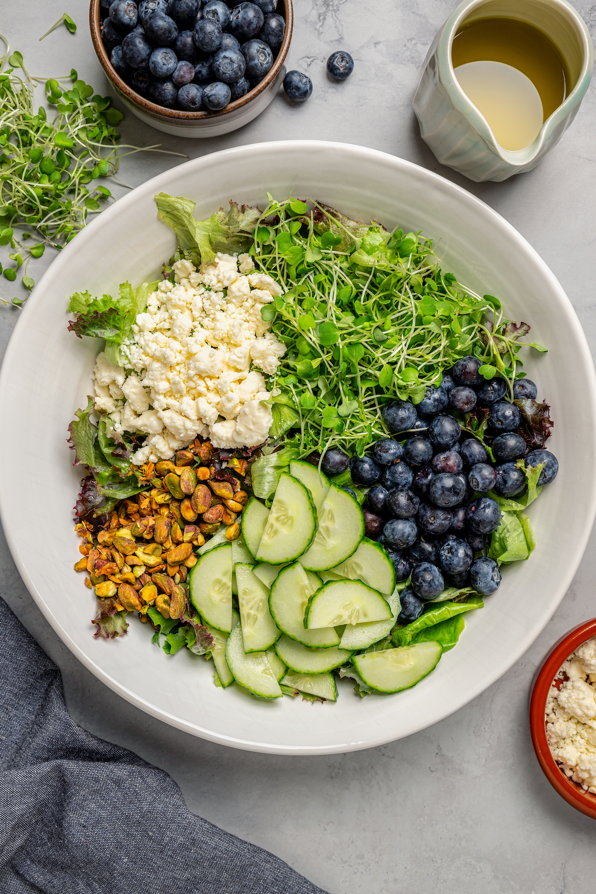Spring Mix Salad with Champagne Dressing is elegant, flavorful, and unique - and only takes minutes to prepare! A nutritious, paleo salad. Salad ingredients arranged in a large, shallow dish.
