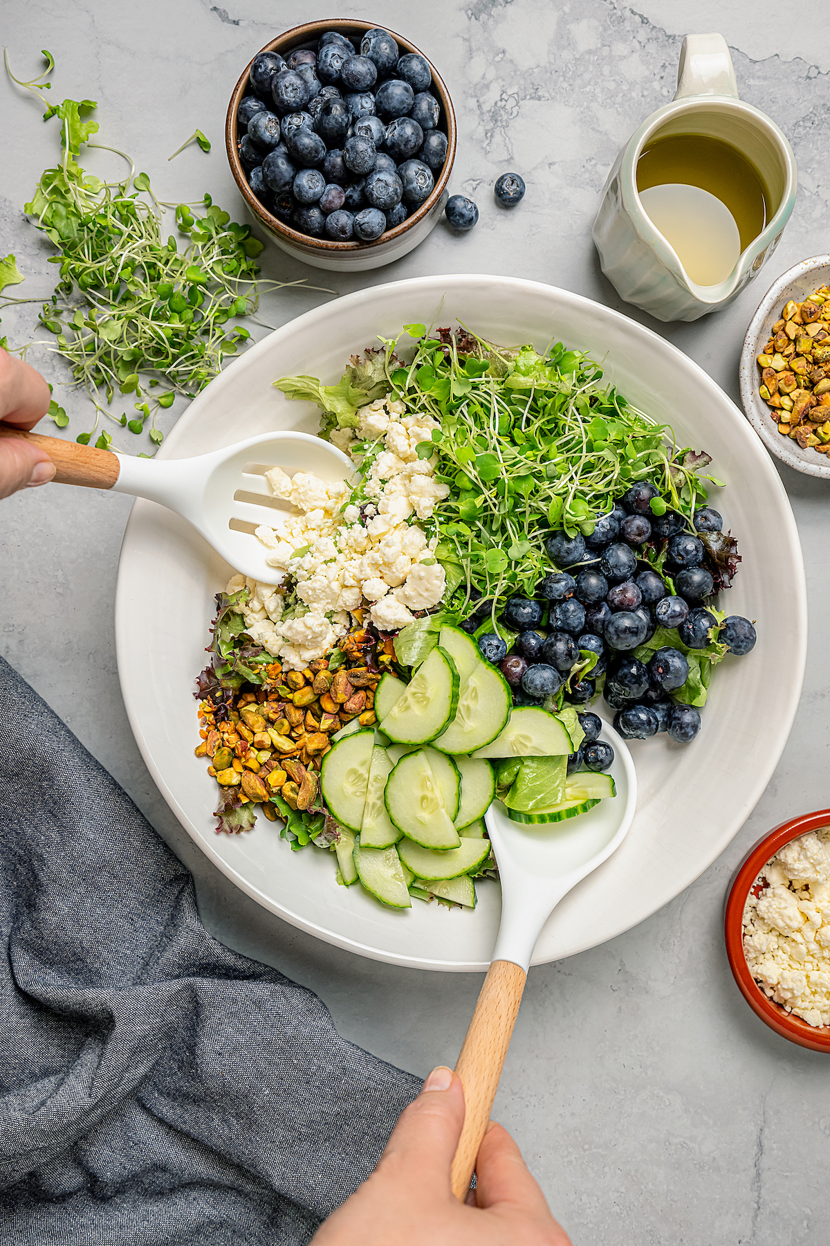 Spring Mix Salad with Champagne Dressing is elegant, flavorful, and unique - and only takes minutes to prepare! A nutritious, paleo salad. Mixing a salad together with salad servers.
