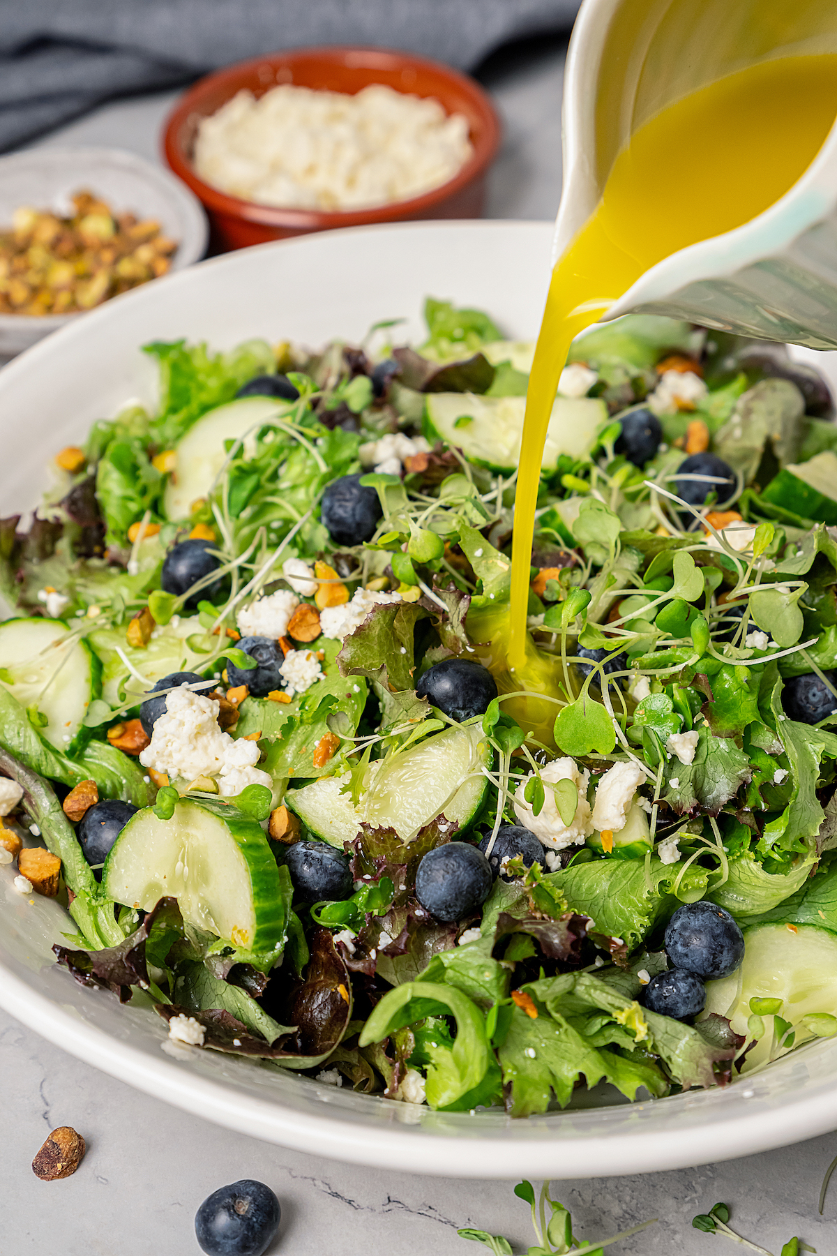 Spring Mix Salad with Champagne Dressing is elegant, flavorful, and unique - and only takes minutes to prepare! A nutritious, paleo salad. Pouring dressing over spring mix salad.