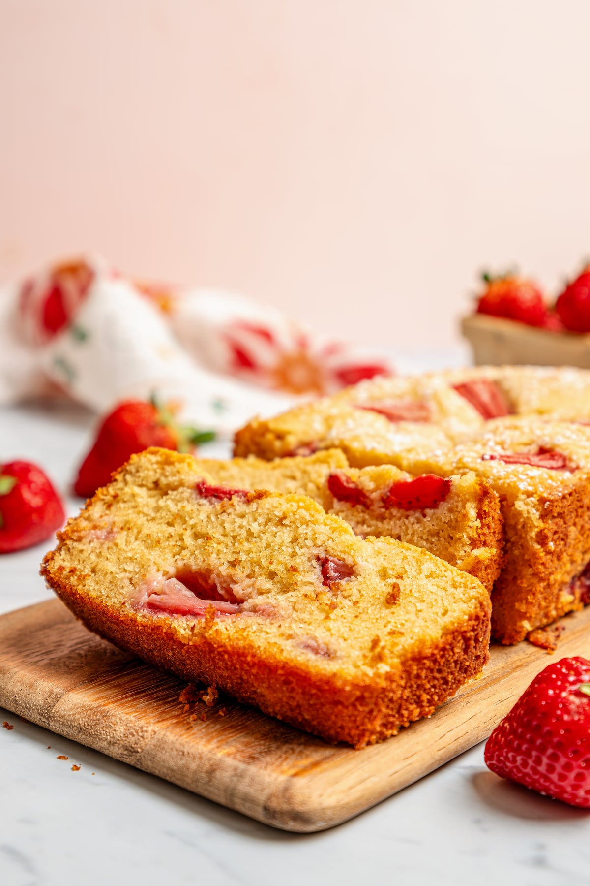 This fluffy, sour cream-strawberry bread recipe with sweet maple syrup is an easy breakfast option with your favorite coffee. Close-up of a fluffy loaf slice with juicy strawberries in it.