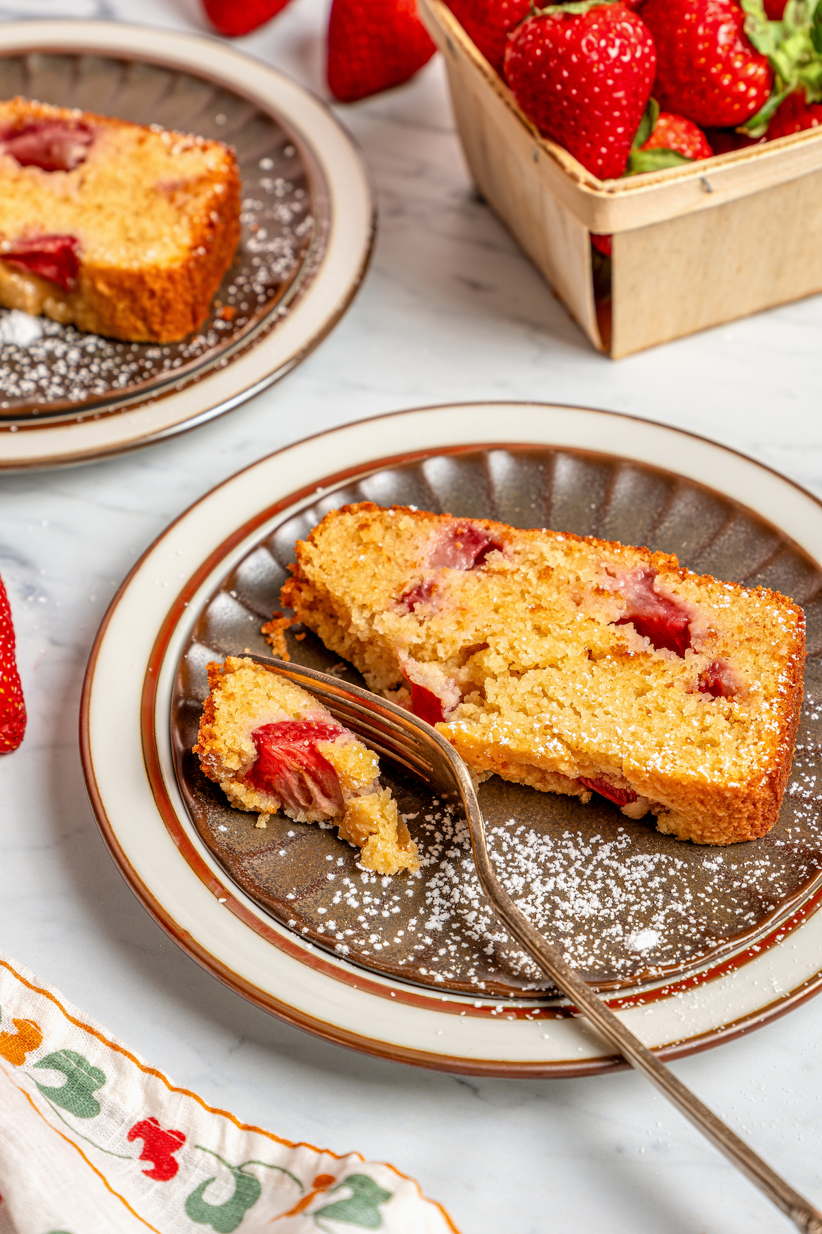 This fluffy, sour cream-strawberry bread recipe with sweet maple syrup is an easy breakfast option with your favorite coffee. Grabbing a piece of buttery strawberry bread with a fork.