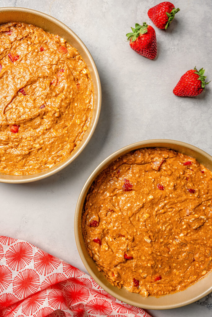 This fluffy strawberry cake recipe with homemade chocolate-maple frosting is an easy but impressive Valentine's Day dessert. Pouring batter into the two cake pans.