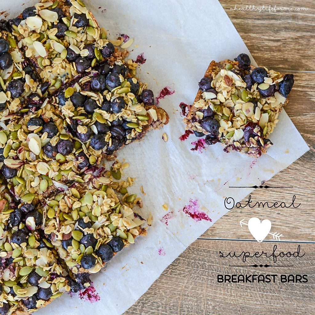 These easy oatmeal breakfast bars with sweet blueberries and pumpkin seeds are a quick high-protein treat for busy mornings. Sliced oatmeal breakfast bars on a piece of parchment paper.
