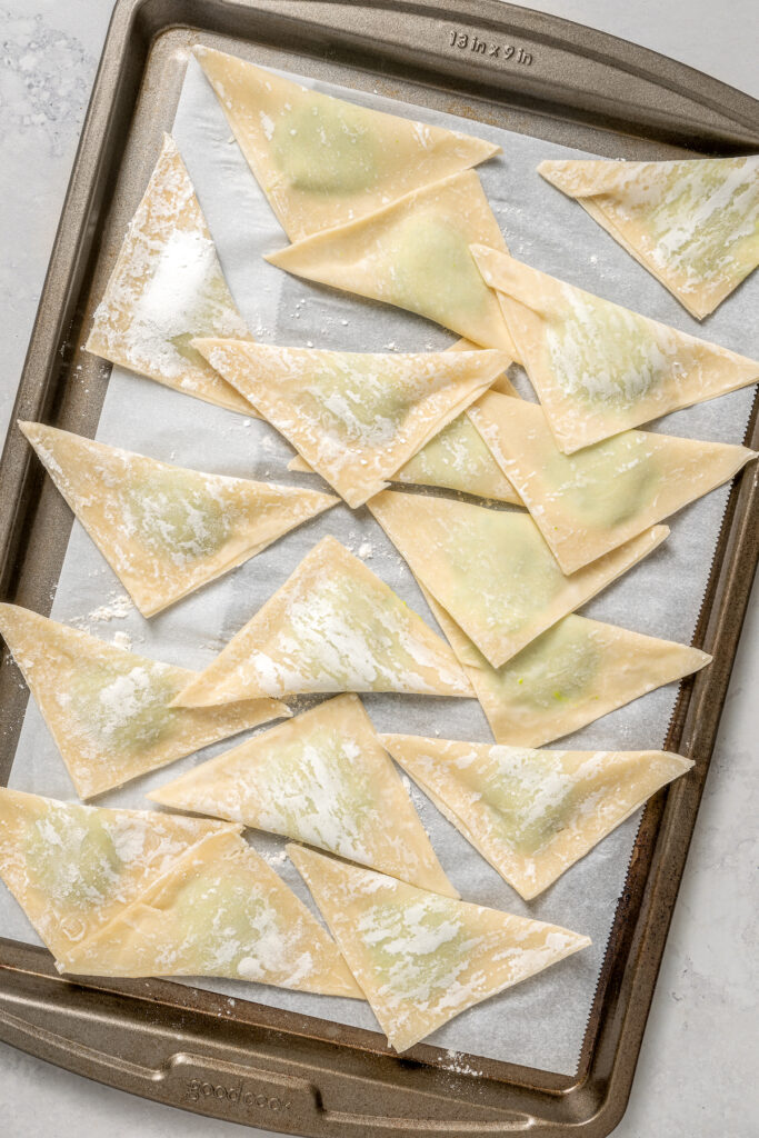 Cheese Ravioli with Peas and Butter Sauce will soon become one of your family's favorites. Easy to make with wonton wrappers! Folding the wonton wrappers to make triangular ravioli.