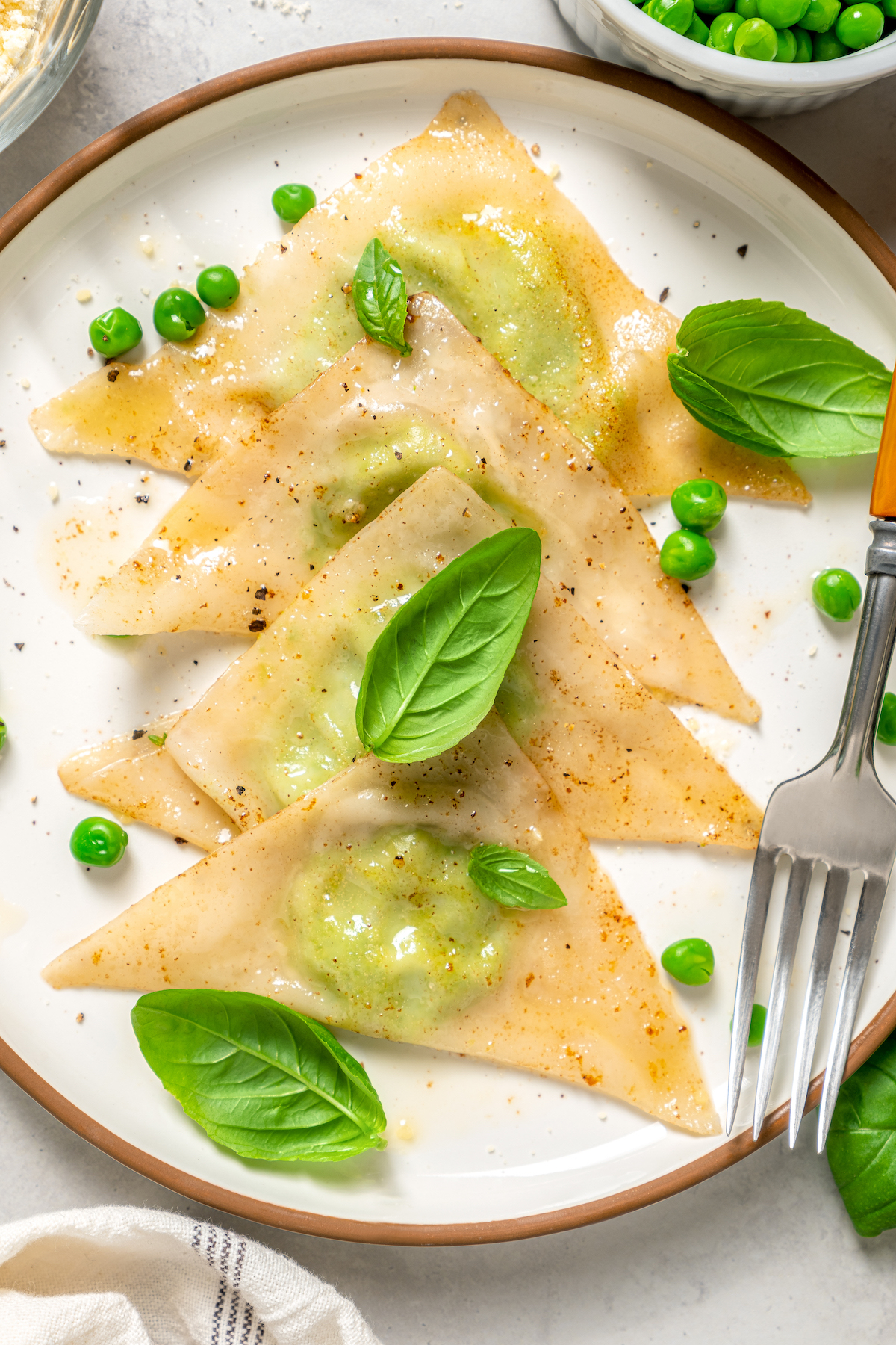 Cheese Ravioli with Peas and Butter Sauce will soon become one of your family's favorites. Easy to make with wonton wrappers! Four homemade wonton ravioli filled with peas.
