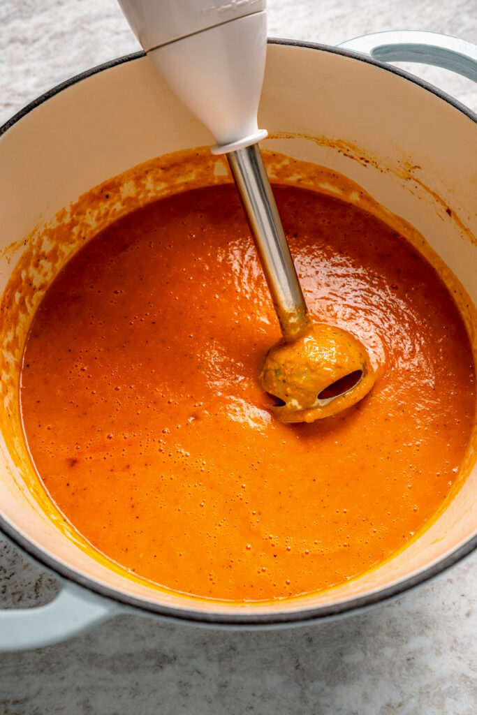 This easy tomato bisque recipe with parmesan and Italian seasoning is a comforting weeknight dinner paired with toasty sliced bread. Blending the bisque.