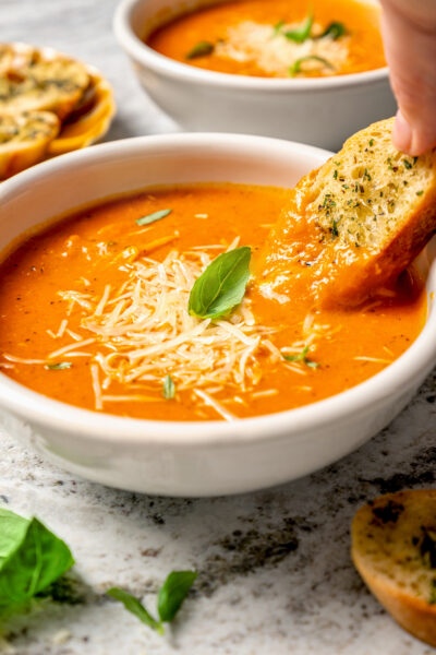 Dipping a slice of bread into the soup.